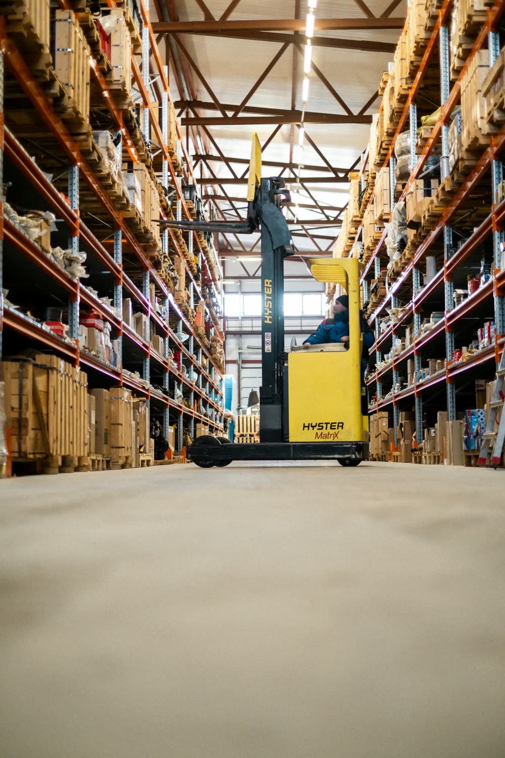 Forklift in a stocked warehouse aisle